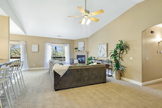 living room with lofted ceiling, light colored carpet, and ceiling fan