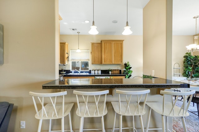 kitchen with pendant lighting, a breakfast bar, and kitchen peninsula