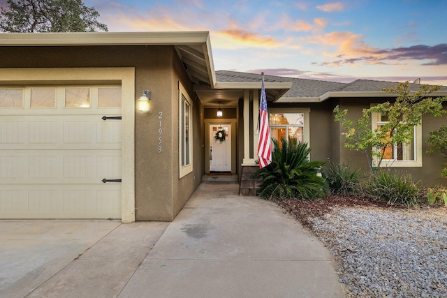 exterior entry at dusk with a garage