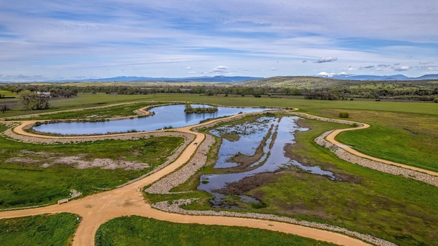 aerial view featuring a water and mountain view and a rural view