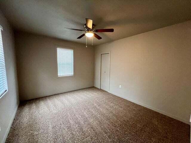 unfurnished room featuring carpet floors and ceiling fan