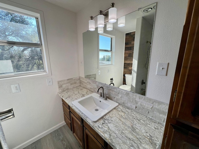 bathroom featuring vanity, wood-type flooring, a shower, and toilet