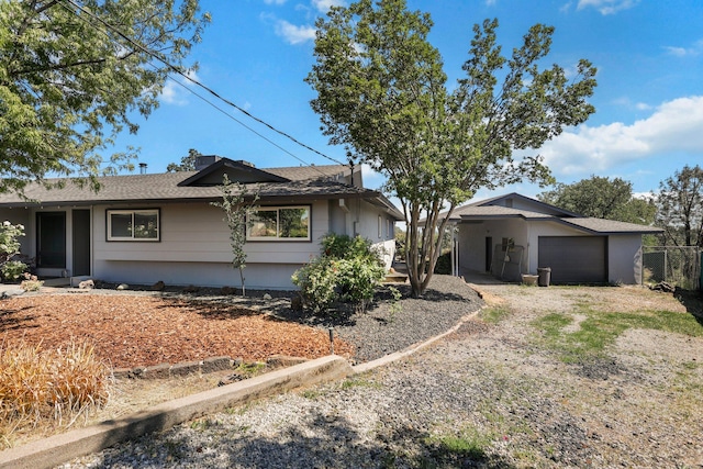ranch-style home featuring an attached garage, driveway, and fence