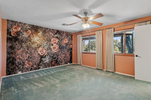 spare room featuring carpet floors, a ceiling fan, visible vents, and baseboards