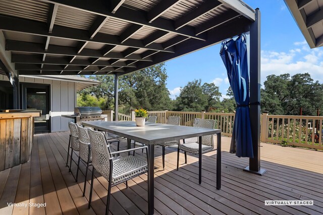 wooden terrace with area for grilling, grilling area, and outdoor dining space