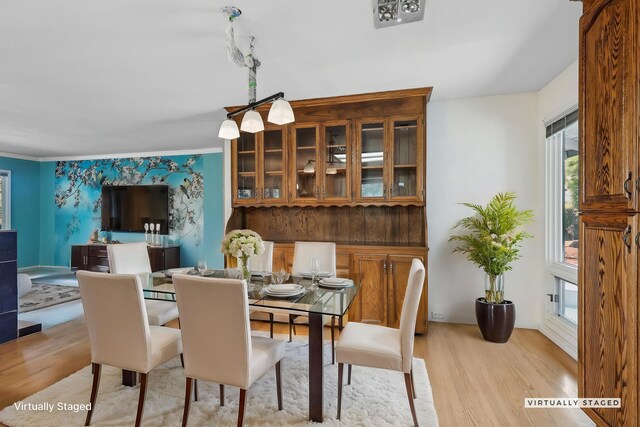 dining room featuring light wood-type flooring and ornamental molding
