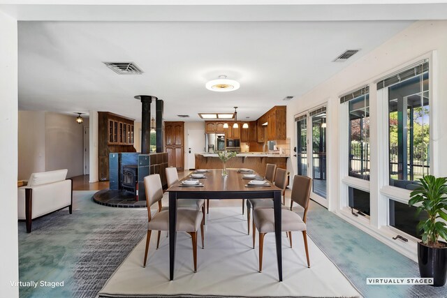 dining space with visible vents and a wood stove
