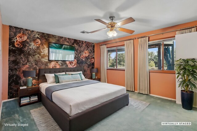 bedroom featuring visible vents, a ceiling fan, an accent wall, carpet floors, and baseboards