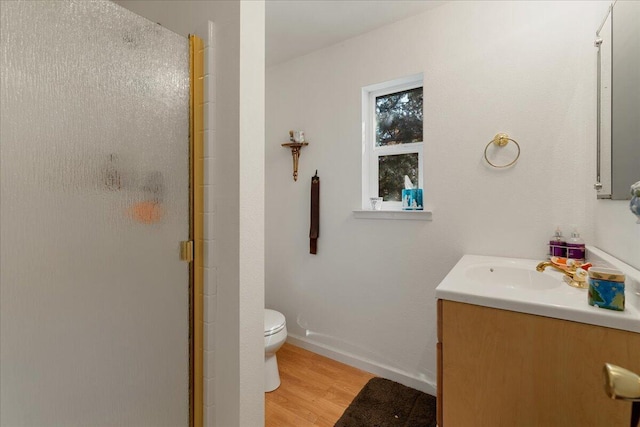 bathroom with vanity, toilet, a shower with door, and hardwood / wood-style floors