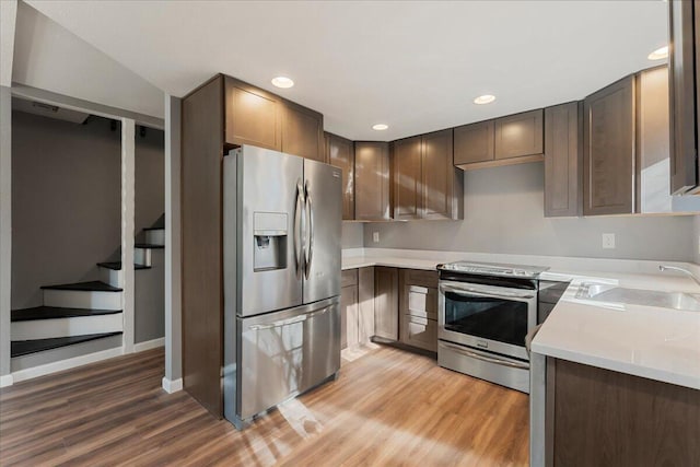 kitchen with stainless steel appliances, light hardwood / wood-style floors, and sink