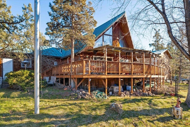 rear view of house featuring a wooden deck and a yard