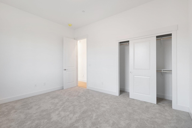 unfurnished bedroom featuring light colored carpet and a closet