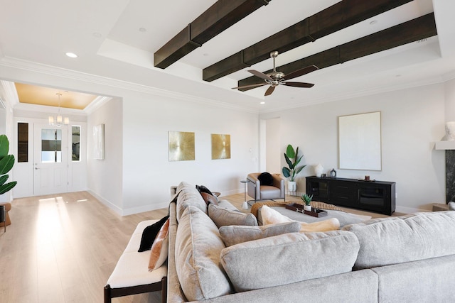 living room with light hardwood / wood-style flooring, a tray ceiling, a fireplace, ornamental molding, and beamed ceiling