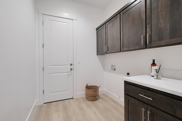 washroom with hookup for a washing machine, light hardwood / wood-style flooring, cabinets, and hookup for an electric dryer