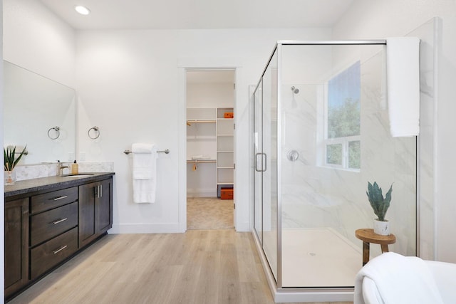 bathroom featuring vanity, hardwood / wood-style floors, and a shower with shower door