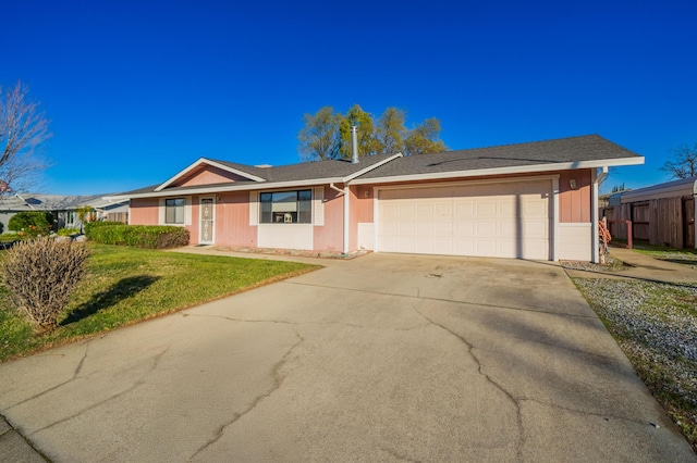 ranch-style home with a garage and a front lawn