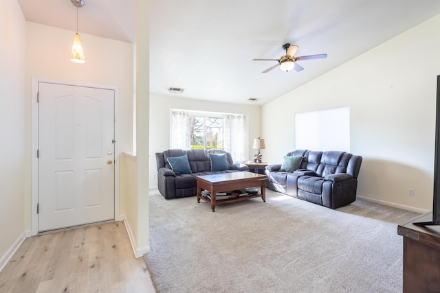 living room featuring lofted ceiling, light colored carpet, and ceiling fan