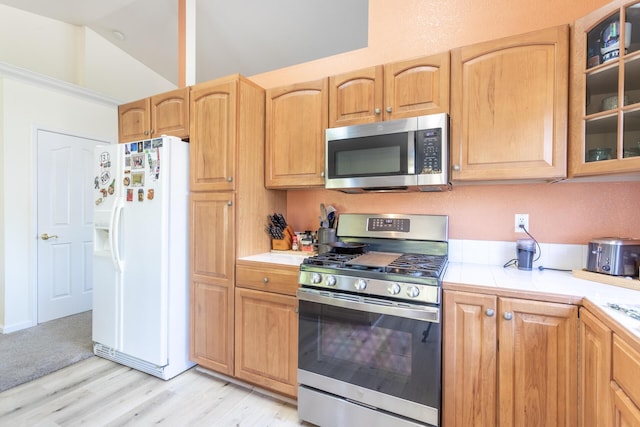 kitchen featuring vaulted ceiling, stainless steel appliances, and light wood-type flooring