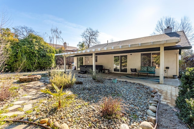 rear view of house featuring a patio area and a hot tub