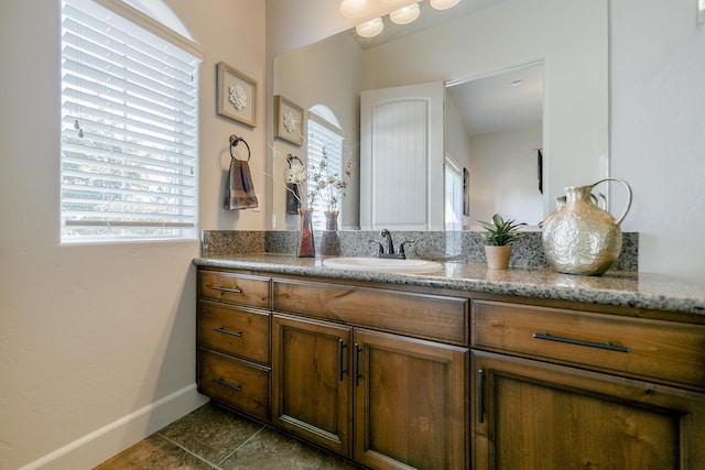 bathroom with a healthy amount of sunlight, tile patterned flooring, and vanity