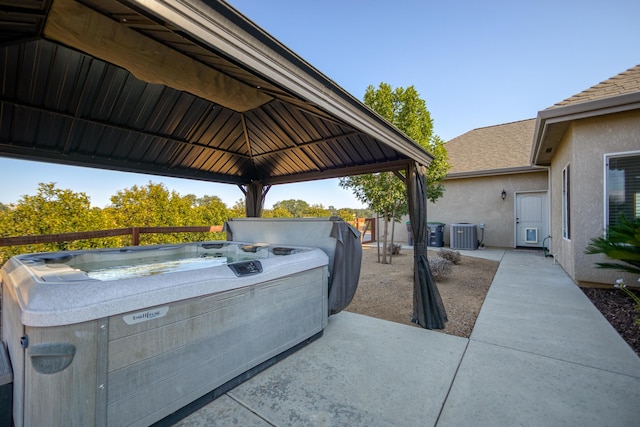 view of patio / terrace featuring a gazebo, a hot tub, and cooling unit