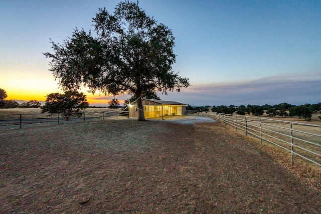 yard at dusk with an outbuilding and a rural view