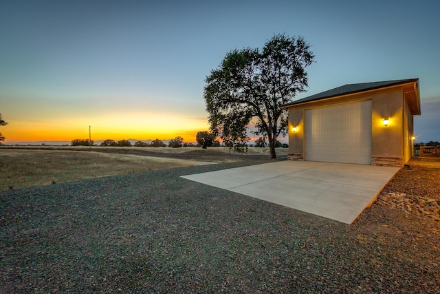 yard at dusk with an outbuilding and a garage