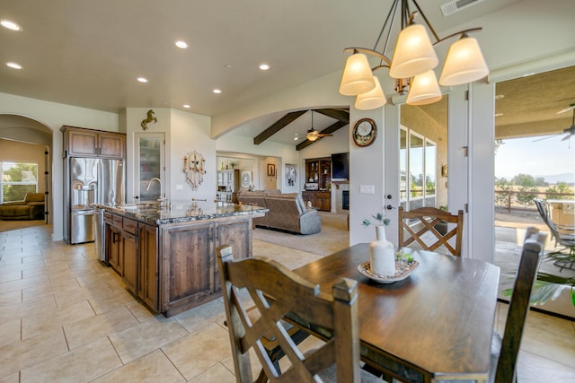 dining space with sink, vaulted ceiling with beams, ceiling fan, and light tile patterned flooring