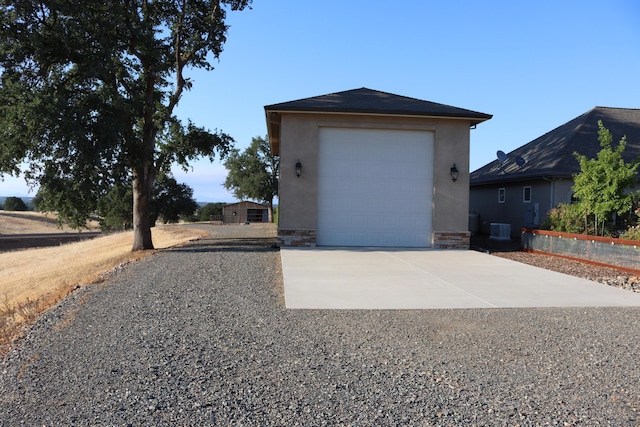 view of side of property with an outbuilding, a garage, and central AC unit