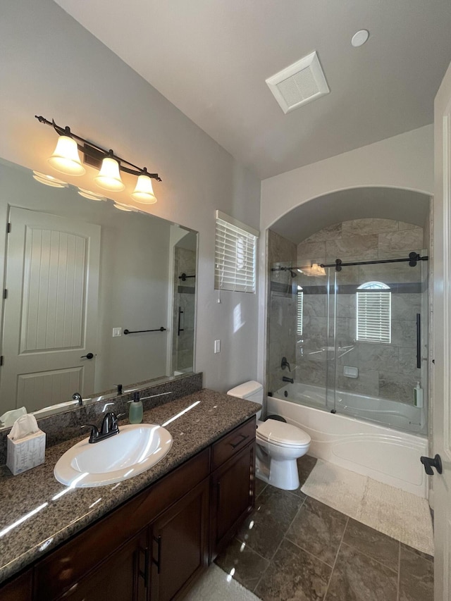 full bathroom featuring vanity, combined bath / shower with glass door, and toilet