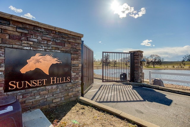 community / neighborhood sign featuring a water view