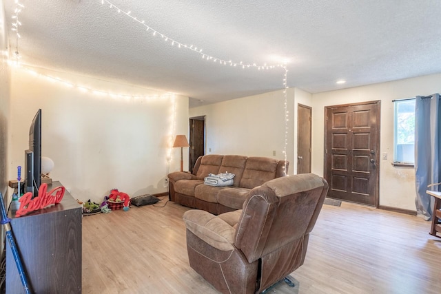 living room with a textured ceiling and light hardwood / wood-style flooring