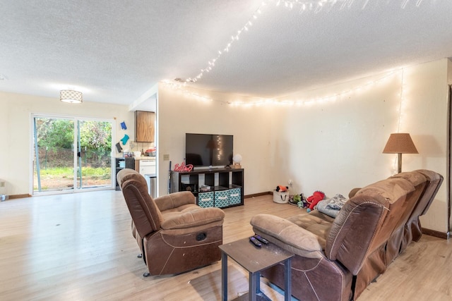 living room with a textured ceiling and light wood-type flooring