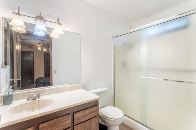 bathroom featuring vanity, toilet, and an enclosed shower