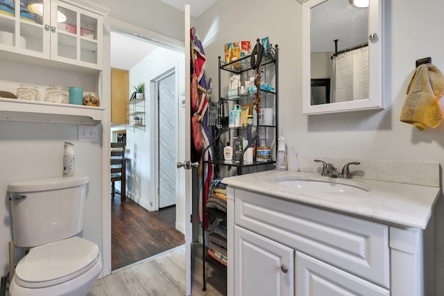 bathroom with vanity, wood-type flooring, and toilet