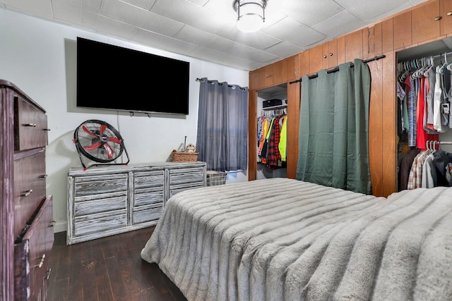 bedroom featuring wooden walls and dark hardwood / wood-style flooring