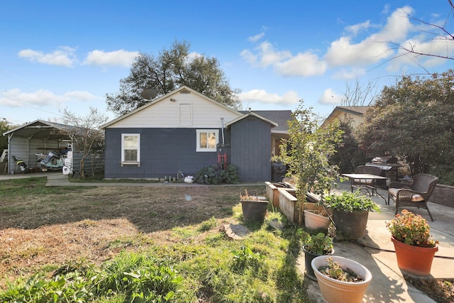 view of side of property with a carport, a patio area, and a lawn