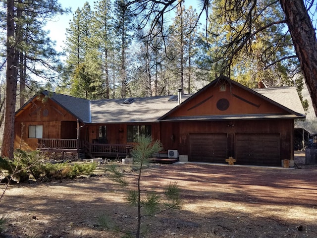 rustic home featuring an attached garage and dirt driveway