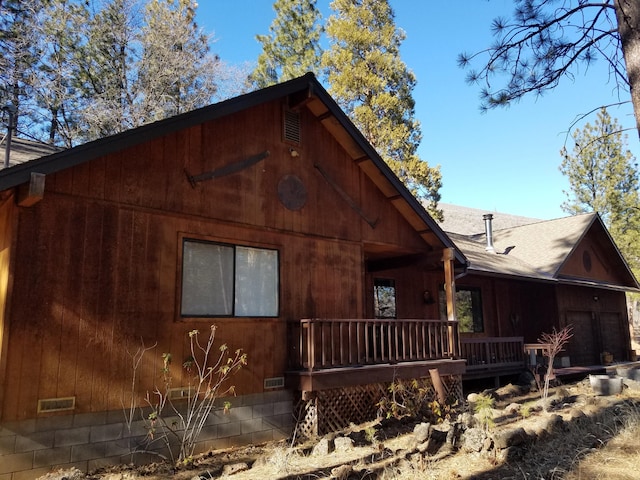 view of property exterior with a shingled roof, crawl space, a porch, and an attached garage