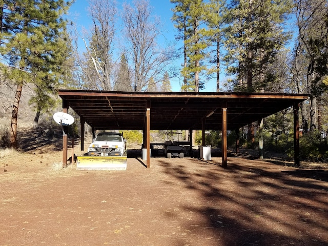 view of parking with driveway and a carport