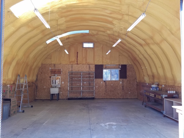 misc room with lofted ceiling and concrete floors