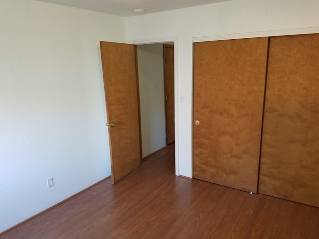 unfurnished bedroom with a closet and wood finished floors