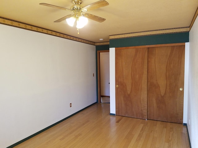 unfurnished bedroom featuring light wood finished floors, a closet, ornamental molding, a ceiling fan, and baseboards