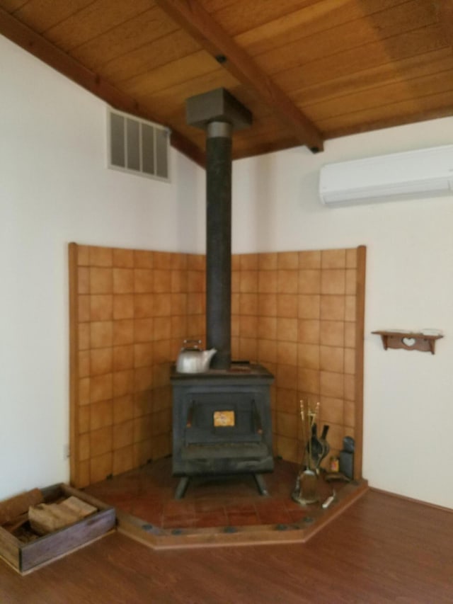 interior details featuring a wood stove, wooden ceiling, wood finished floors, and visible vents