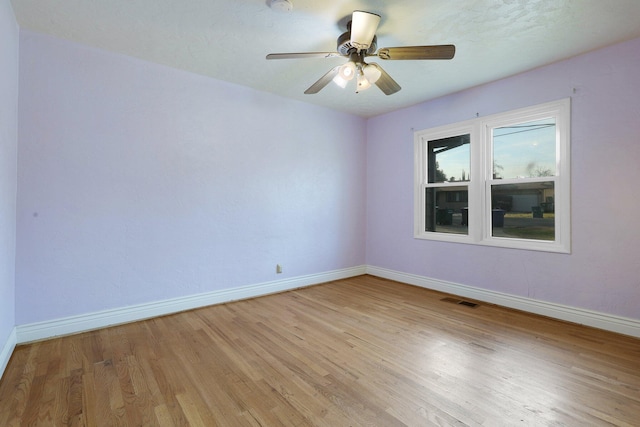 spare room with ceiling fan and light wood-type flooring