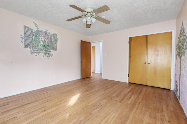 unfurnished bedroom featuring a closet, ceiling fan, light hardwood / wood-style floors, and a textured ceiling