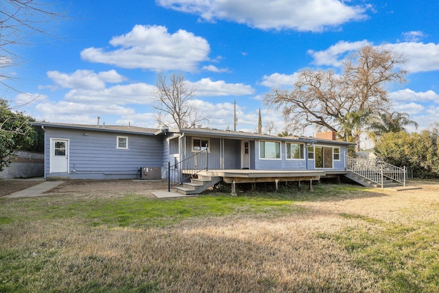 rear view of property featuring a yard and a deck