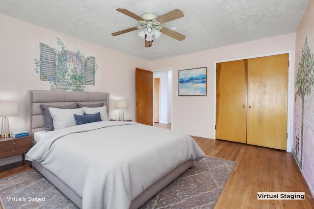 bedroom with ceiling fan, hardwood / wood-style floors, and a textured ceiling