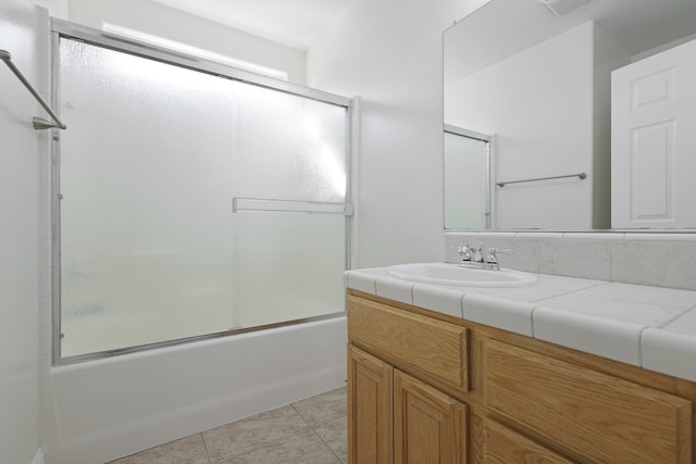 bathroom with tile patterned flooring, vanity, and enclosed tub / shower combo