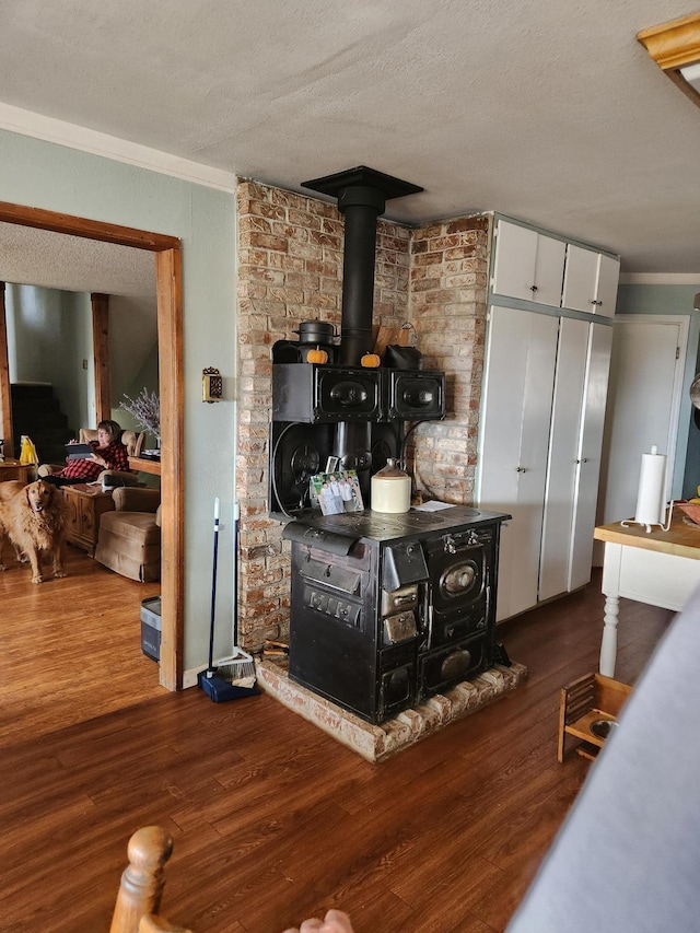 bar with dark wood-type flooring, white cabinetry, crown molding, a textured ceiling, and a wood stove